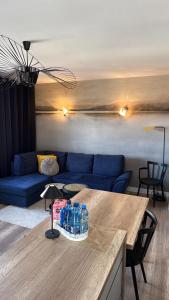 a living room with a blue couch and a table at Apartament - U Alicji in Konin