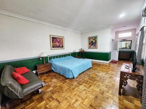 a bedroom with a bed and a couch at Kulem Gempol in Bandung