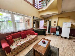 a living room with a red couch and a table at Kulem Gempol in Bandung