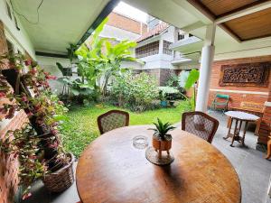 a wooden table and chairs on a patio at Kulem Gempol in Bandung
