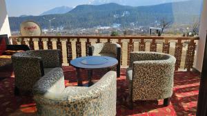 a group of chairs and a table on a balcony at Grand Mumtaz Tangmarg in Tangmarg +4 photos