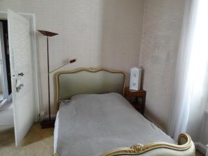 a bedroom with a bed and a lamp and a window at Maison centre-ville et proche du Circuit des 24H in Le Mans