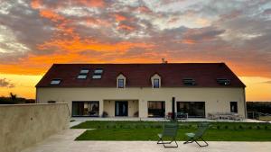 a house with two chairs in front of a sunset at L'Echo du Bonheur in Vaumas