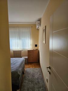 a small bedroom with a bed and a bathroom at Apartman JOVANA in Dušanovac (historical)