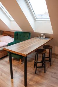 a dining room with a wooden table and a green chair at Ubytování 1kk ve Zlonicích in Slaný