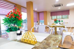 a restaurant with white chairs and tables and flowers at JANNAH VILLAS - GHANA in Adentan