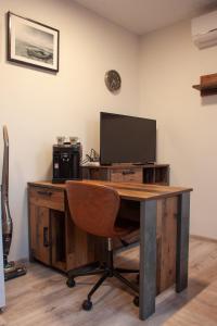 a desk with a television and a chair in a room at Ubytování 1kk ve Zlonicích in Slaný