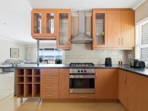 a kitchen with wooden cabinets and a stove top oven at Coney Glen Penthouse in Knysna