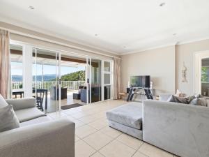 a living room with a couch and a table at Coney Glen Penthouse in Knysna