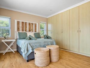 a bedroom with a bed with two stools in it at Coney Glen Penthouse in Knysna