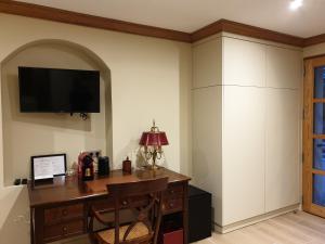 a room with a desk and a tv on the wall at Suite junior côté Vercors in Seyssins