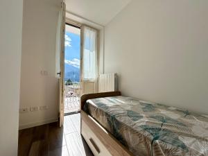 a bedroom with a bed and a large window at Relax Home in Clusone