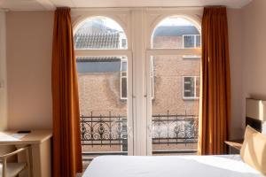 a bedroom with a window with a view of a building at CS Hotel in Amsterdam