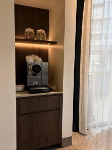 a kitchen with a microwave on a counter next to a window at Hotel Pax in Diksmuide