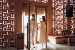 a man and a woman standing in front of a door at Cyrus Villa Seminyak by Ini Vie Hospitality in Seminyak
