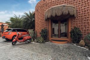 a red scooter parked in front of a building at Cyrus Villa Seminyak by Ini Vie Hospitality in Seminyak