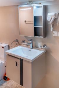 a bathroom with a sink and a mirror at Glenbourne Bungalow in Galaha Town +25 photos