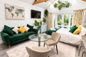 a bedroom with a green couch and a glass table at The Garden Hideaway Central Corbridge in Corbridge