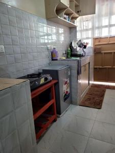 a kitchen with a stove and a refrigerator at Baraka Stay,Kenol,Gitura,Murang'a in Gitura