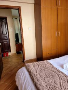 a bedroom with a bed and a wooden cabinet at Baraka Stay,Kenol,Gitura,Murang'a in Gitura
