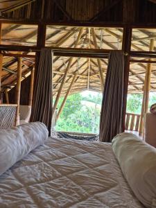 a large bed in a room with a large window at Villa Bambu Juma & Bakal in Kotasuka