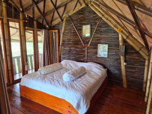 a bedroom with a bed with two pillows on it at Villa Bambu Juma & Bakal in Kotasuka
