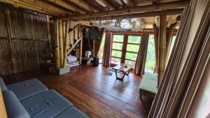 a living room with a couch and wooden floors at Villa Bambu Juma & Bakal in Kotasuka
