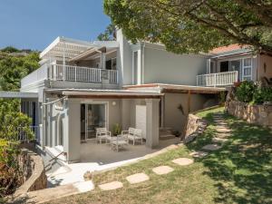 a white house with a patio and a yard at Coney Glen Penthouse in Knysna