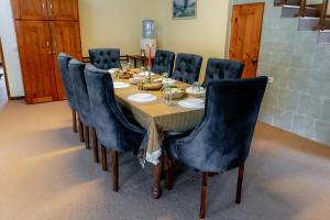 a dining room table with blue chairs around it at Glenbourne Bungalow in Galaha Town