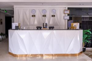 eine große weiße Theke in einem Raum mit Uhren an der Wand in der Unterkunft Al Muhaidb Residence Al Malaz 7 - Economic in Riad
