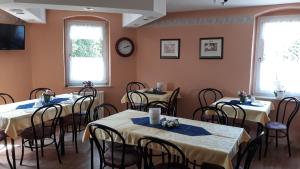 a dining room with tables and chairs and a clock at Pension Partzsch in Siebenlehn