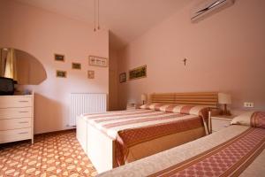 a bedroom with two beds and a dresser and a tv at Albergo Tre Stelle in Marina di Grosseto