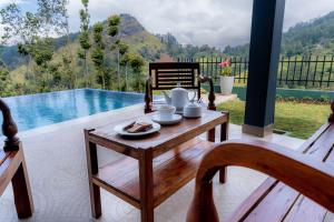 a table with a plate of food on top of a patio at Glenbourne Bungalow in Galaha Town