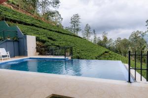 a swimming pool with a hill in the background at Glenbourne Bungalow in Galaha Town