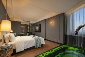 a hotel room with a bed and a tub at 总统號外酒店 President HaoWai Hotel Guangzhou in Guangzhou