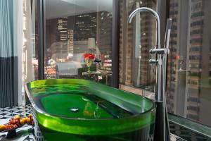 a green bath tub in a room with a window at 总统號外酒店 President HaoWai Hotel Guangzhou in Guangzhou