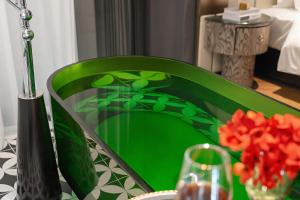 a green chair at a table with a vase of flowers at 总统號外酒店 President HaoWai Hotel Guangzhou in Guangzhou