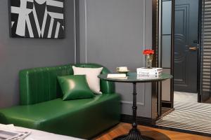 a green couch and a table in a room at 总统號外酒店 President HaoWai Hotel Guangzhou in Guangzhou
