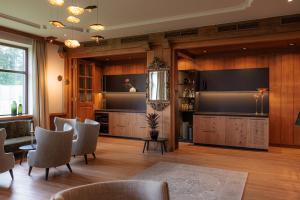 a living room with chairs and a large screen television at Royal Hotel Hinterhuber in Brunico