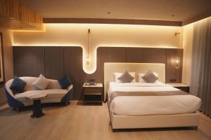 a bedroom with a bed and a couch and a chair at Love Kush Hotel in Kishangarh +111 photos