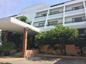 a white building with trees in front of it at Sirin Hotel Hua Hin in Hua Hin