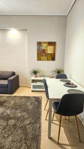 a living room with a table and chairs and a couch at Efrosini's by the sea apartment in Chalkida