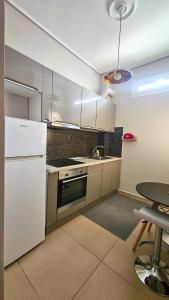 a kitchen with a white refrigerator and a table at Efrosini's by the sea apartment in Chalkida +11 photos