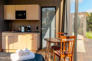 a kitchen and dining room with a table and chairs at Pulli Country Club - Private Sauna & River View in Pärnu