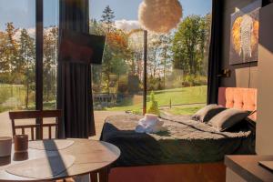 a bedroom with a bed and a large window at Pulli Country Club - Private Sauna & River View in Pärnu