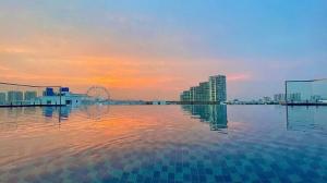 Ein Wasserbecken mit einer Stadt im Hintergrund in der Unterkunft Realux Hotel FLC Sam Son in Sầm Sơn
