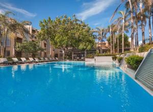 a swimming pool with palm trees and blue water at Henann Regency Resort and Spa in Boracay