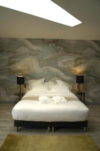 a bedroom with a white bed with a painting on the wall at Villa d'Eaux in Villers-sur-Mer