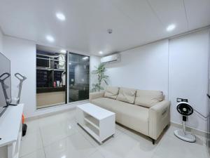 a white living room with a couch and a table at 泊金青年旅舍-深圳北站店 in Shenzhen