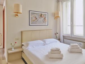 a bedroom with a white bed with two towels on it at Hotel L'Aretino in Arezzo